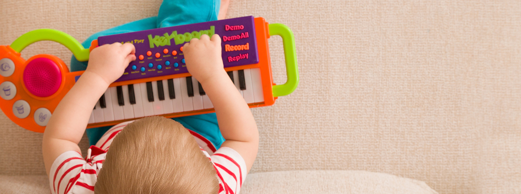 toddler playing with toy piano